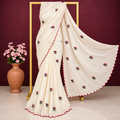 Exclusive off-white cotton embroidered saree with scalloped borders.